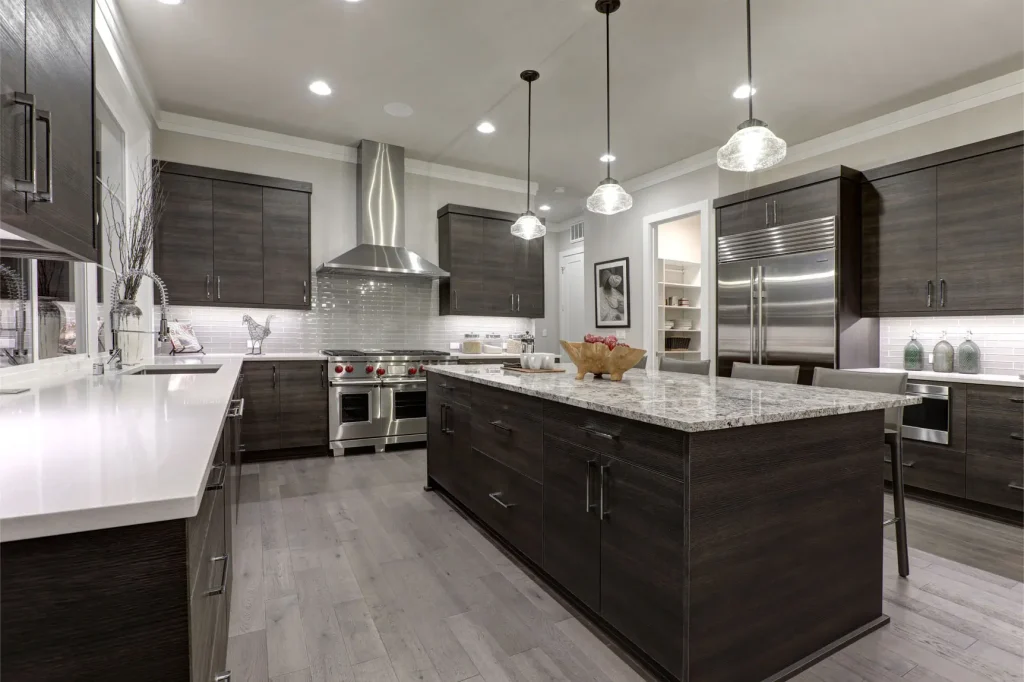 Modern gray kitchen features dark gray flat front cabinets paired with white quartz countertops and a glossy gray linear tile backsplash.