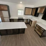Modern kitchen with marble countertops and black painted cabinetry.